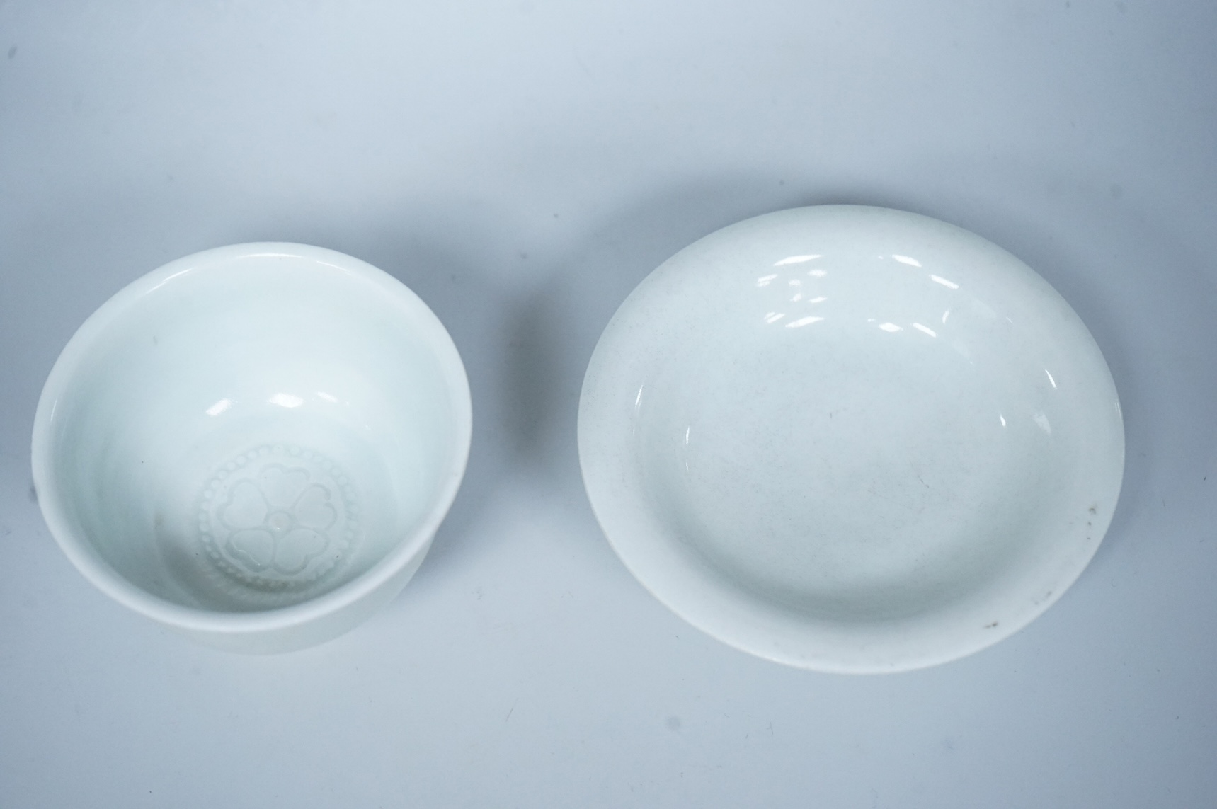 A Chinese white glazed stem cup and similar dish, tallest 7cm